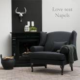 Donkergrijze oorfauteuil bij de open haard