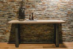 Stehtisch aus Holz vor Natursteinwand