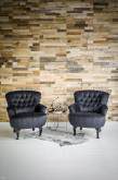 Donkere getufte fauteuils voor een houten wand