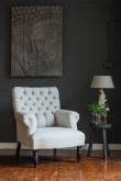 Witte oorfauteuil voor een donkere bakstenen muur